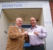 Lion Ron Webb presenting cheque for £100 to Honiton College FD Gary Wills